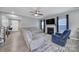 Spacious living room with fireplace, ceiling fan, plush seating, and gray wood flooring at 1018 Hinson Forest Rd, Monroe, NC 28110