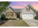 Inviting home exterior with brick accents, two-car garage, manicured lawn, and a welcoming front entrance at 108 Toxaway St, Mooresville, NC 28115