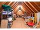 Spacious attic with exposed wood beams and plywood flooring for ample storage, illuminated by a central light at 1116 Landons Ct, China Grove, NC 28023