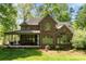 Back exterior of the house with a brick facade, back porch, and large backyard at 1116 Landons Ct, China Grove, NC 28023