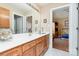 Bathroom featuring a double sink vanity, a large mirror, and an open door with a view into the bedroom at 1116 Landons Ct, China Grove, NC 28023