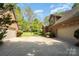 Long driveway to the home, a basketball hoop, extra garage and manicured landscaping at 1116 Landons Ct, China Grove, NC 28023