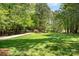 Expansive green lawn leading to a tree-lined driveway offers a tranquil and private setting at 1116 Landons Ct, China Grove, NC 28023