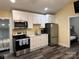 The kitchen features new stainless steel appliances, white cabinets, and modern countertops at 113 Hideaway Trl, Mount Gilead, NC 27306