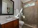 A bathroom featuring a wood vanity, a marble countertop, a glass enclosed shower and a window at 11447 Egrets Point Dr, Charlotte, NC 28278