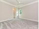 This bedroom features neutral walls, carpet, ceiling fan, window, and a spacious closet at 11447 Egrets Point Dr, Charlotte, NC 28278