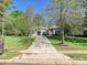 Charming single-story home features a well-manicured lawn, mature trees, and long driveway leading to the entrance at 11447 Egrets Point Dr, Charlotte, NC 28278
