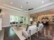 Bright and airy living room featuring large windows, stylish seating, and views of the backyard and the kitchen at 11447 Egrets Point Dr, Charlotte, NC 28278