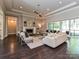 Bright living room with a cozy fireplace, elegant furnishings, and large windows overlooking the backyard at 11447 Egrets Point Dr, Charlotte, NC 28278