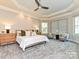 This primary bedroom features neutral walls, carpet, tray ceiling, ceiling fan, and an abundance of natural light at 11447 Egrets Point Dr, Charlotte, NC 28278