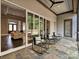 A covered patio featuring rocking chairs and a view to the living room through sliding glass doors at 11447 Egrets Point Dr, Charlotte, NC 28278