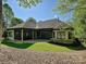Beautiful home featuring an outdoor patio and a screened-in porch, surrounded by lush greenery at 11447 Egrets Point Dr, Charlotte, NC 28278
