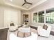 This sitting room features neutral walls, ceiling fan, hardwood floors and white chairs with decorative pillows at 11447 Egrets Point Dr, Charlotte, NC 28278