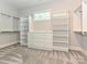 This walk-in closet has custom shelving and drawers for plenty of storage with neutral carpeting and walls at 11447 Egrets Point Dr, Charlotte, NC 28278