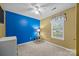 Bedroom with blue and yellow accent walls, natural light, and a ceiling fan at 117 Heath Ln, Mooresville, NC 28117