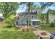 Expansive backyard featuring a patio, sunroom, a fire pit area with chairs and mature trees at 11700 Fernhurst Ln, Charlotte, NC 28277