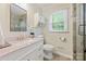 Elegant bathroom featuring a marble countertop, vanity, stylish mirror, and modern fixtures at 11700 Fernhurst Ln, Charlotte, NC 28277