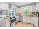 Updated kitchen featuring white cabinets, stainless steel appliances, and a window view of lush greenery at 11700 Fernhurst Ln, Charlotte, NC 28277