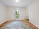 Inviting living room with light walls, wood floors, and a window with views of the front yard at 11700 Fernhurst Ln, Charlotte, NC 28277