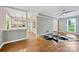 Open-concept living room with hardwood floors flowing into a kitchen with white cabinets and stainless appliances at 11700 Fernhurst Ln, Charlotte, NC 28277