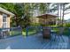 View of the back deck with an umbrella table, overlooking the backyard surrounded by mature trees at 121 Shagbark Ln, Mooresville, NC 28115
