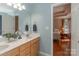 Bathroom with a double sink vanity featuring marble countertop and view into the primary bedroom at 121 Shagbark Ln, Mooresville, NC 28115