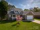 Two-story brick home with well manicured lawn, a two-car garage, and a charming front porch at 121 Shagbark Ln, Mooresville, NC 28115
