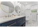 Bright bathroom featuring a stylish blue double vanity, modern fixtures, and elegant round mirrors at 12822 Diamond Dr, Pineville, NC 28134