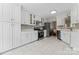 Bright kitchen features white cabinets, stainless steel appliances, and tile backsplash at 12822 Diamond Dr, Pineville, NC 28134