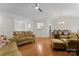 Open living room featuring hardwood floors, ceiling fan, and a view into the dining area at 12822 Diamond Dr, Pineville, NC 28134
