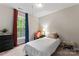 Bright bedroom with a twin bed, orange chair, black dresser, and natural light at 12905 Bullock Greenway Blvd, Charlotte, NC 28277