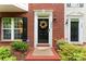Up close view of townhome entryway with black front door, wreath, and security system sign at 12905 Bullock Greenway Blvd, Charlotte, NC 28277