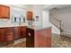 Well-lit kitchen with a center island, modern sink, and view of staircase at 12905 Bullock Greenway Blvd, Charlotte, NC 28277