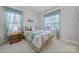 Comfortable bedroom with neutral walls, bright windows with patterned curtains, and a queen-sized bed with decorative pillows at 141 Forsythia Ln, Tega Cay, SC 29708