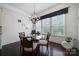 The breakfast nook features natural light, a modern chandelier, and a glass table with seating for four at 141 Forsythia Ln, Tega Cay, SC 29708
