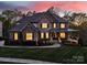 Stunning exterior of a two-story home at dusk, showcasing its brick facade, illuminated windows, and welcoming front porch at 141 Forsythia Ln, Tega Cay, SC 29708