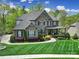 Beautiful two-story brick home with a manicured lawn and a charming front porch, perfect for relaxing and enjoying the outdoors at 141 Forsythia Ln, Tega Cay, SC 29708