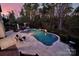 A picturesque backyard pool featuring a waterfall, fire bowls, and lounge chairs surrounded by lush landscaping at 141 Forsythia Ln, Tega Cay, SC 29708