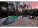 A luxurious backyard pool with travertine tile and fire bowls, creating a serene and upscale outdoor oasis at 141 Forsythia Ln, Tega Cay, SC 29708