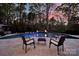 Inviting backyard pool area with travertine tile, fire bowls, and comfortable patio seating, perfect for outdoor relaxation at 141 Forsythia Ln, Tega Cay, SC 29708