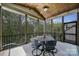 The screened porch features an outdoor dining space, ceiling fan, and views of the landscaped yard at 141 Forsythia Ln, Tega Cay, SC 29708