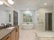 Bright bathroom with a soaking tub, glass enclosed shower, dual vanities, and modern fixtures at 1523 Saint George St, Charlotte, NC 28205