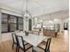 Open concept dining room with modern chandelier, view to kitchen and hardwood flooring at 1523 Saint George St, Charlotte, NC 28205