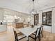 Dining room with hardwood floors, open concept kitchen, modern chandelier, and seating for six at 1523 Saint George St, Charlotte, NC 28205
