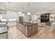 Open kitchen with an island view to a fireplace, light hardwood floors, and custom finishes at 1523 Saint George St, Charlotte, NC 28205