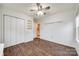 Bright bedroom with wood-look floors, a ceiling fan, closet, and built in shelving at 1545 Wimbleton Woods Dr, Fort Mill, SC 29708