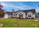 Charming single Gathering home featuring light green siding, well manicured lawn, and an attached two car garage at 1545 Wimbleton Woods Dr, Fort Mill, SC 29708