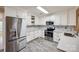 Bright kitchen with stainless steel appliances, white cabinets, subway tile backsplash, and gray floors at 1545 Wimbleton Woods Dr, Fort Mill, SC 29708