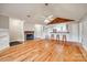 Spacious living room with hardwood floors, fireplace, fan, and breakfast bar looking into the kitchen at 1545 Wimbleton Woods Dr, Fort Mill, SC 29708