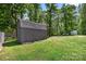 Backyard shed in the green, wooded backyard with blue sky overhead at 1756 Martin Rd, Kings Mountain, NC 28086
